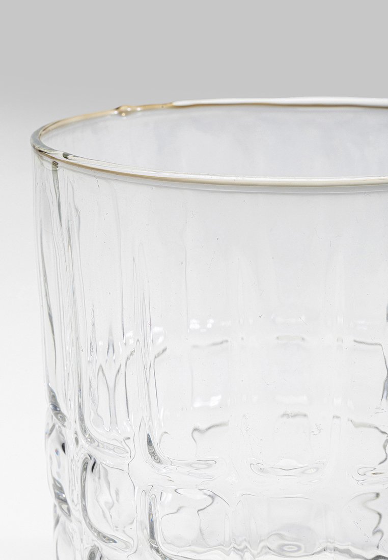 Vaso de vidrio transparente con superficie texturada, forma curvada y delgado borde dorado que resalta la parte superior para un toque refinado.