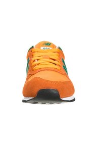 Pomarańczowe zamszowe sneakersy z czarną gumową podeszwą, zielonymi akcentami i pomarańczowymi sznurowadłami. Posiadają zaokrąglony czubek i wyprofilowany język.