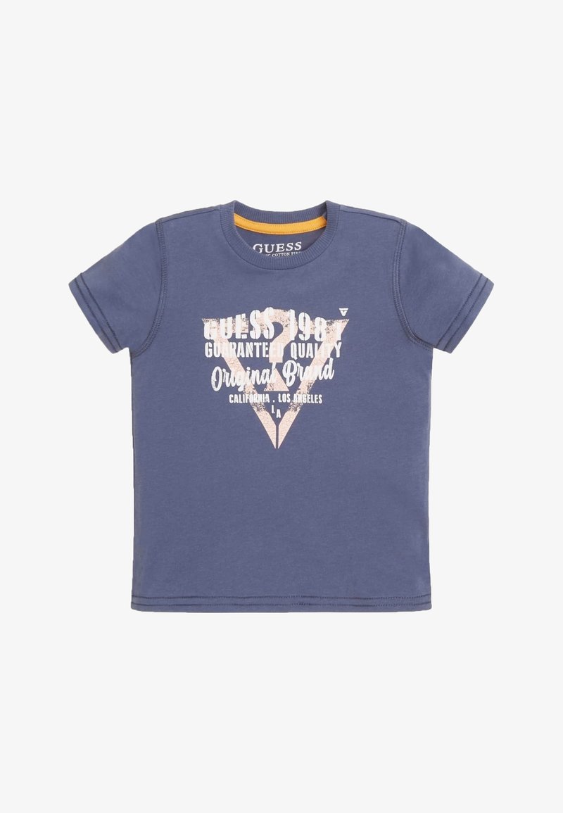 T-shirt Guess bleu à manches courtes avec col rond et texte blanc indiquant "Guess 1981 Guaranteed Quality Original Brand California Los Angeles"