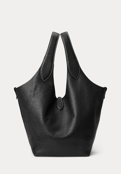 Zwarte gestructureerde leren tote-tas met brede handvatten en minimale stiksels, rechtopstaand tegen een lichte achtergrond afgebeeld.