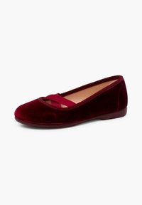 Bailarinas de terciopelo burdeos con punta redonda y detalle de tira cruzada. El zapato presenta una textura suave y un diseño de perfil bajo.