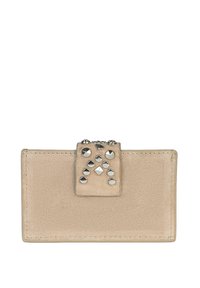 Cartera de ante beige con cierre a presión adornado con tachuelas, que presenta diversas tachuelas de metal plateado dispuestas en arreglos geométricos. Textura suave y diseño minimalista.