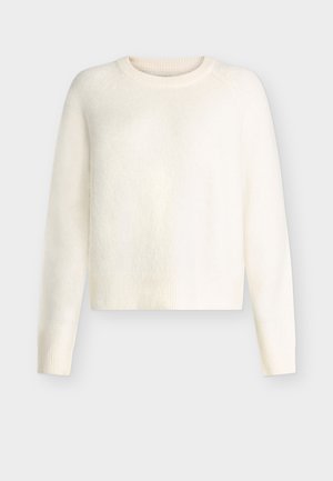 Hvit cropped genser laget av mykt, teksturert stoff. Har rund hals og ribbestrikkede ermer med sømløse raglanermer.