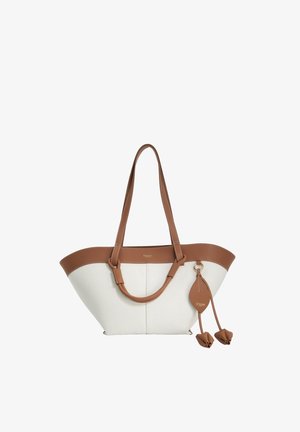 Sac cabas blanc avec bordure en cuir marron, longues anses et pampilles décoratives en cuir sur un porte-clés avec boucle.