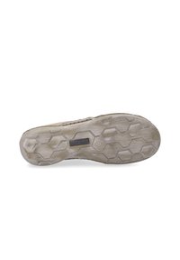Suola di una scarpa con una superficie in gomma beige testurizzata caratterizzata da un motivo esagonale e un piccolo logo. Aspetto leggermente usurato.