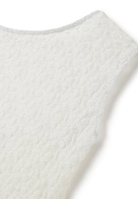 Tessuto bianco testurizzato con un motivo sottile. Presenta un collo a barca e un bordo a contrasto lungo i margini. Finitura morbida e tattile.