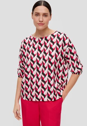 Top svasato in tessuto con un motivo a zigzag ripetuto in rosa, bianco e nero. Presenta una scollatura ampia e maniche arrotolate.