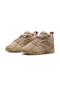 Tan athletic shoes with a textured upper, mesh panels, and red accents. Features a low-top design and rubber sole with grip pattern.