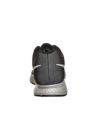 Zapatilla deportiva negra y gris vista desde atrás, con un patrón texturizado y un logo blanco en el talón.