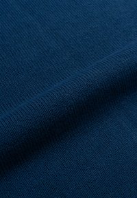 Tessuto lavorato a maglia blu scuro con un fine motivo testurizzato. Il materiale appare morbido con una leggera lucentezza, mostrando una superficie liscia e uniforme.