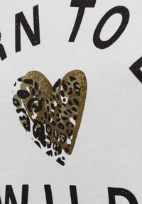 White fabric featuring a prominent gold glitter heart with a leopard print pattern, accompanied by black text in a bold font.