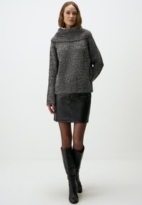 Pull en tricot gris foncé avec col replié, associé à une mini-jupe en cuir noire et des bottes noires arrivant au genou. Textures lisses tout au long.