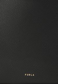 Melna teksturēta ādas maks ar gludu apdari, apakšā ar zelta "FURLA" logotipu. Kompakta taisnstūra forma.