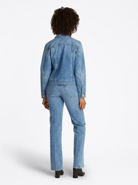 Jaqueta de denim azul claro e jeans combinando, apresentando um design clássico, fechos de botão e um acabamento ligeiramente texturizado.