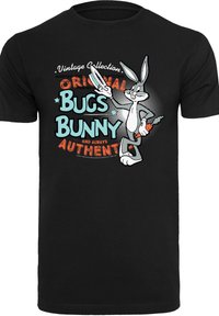 Svart bomull T-skjorte med et grafisk trykk av Bugs Bunny som holder en gulrot, med flerfarget tekst som leser "Original Bugs Bunny" og dekorasjoner.