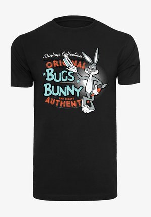 Černé bavlněné tričko s grafikou Bugs Bunnyho držícího mrkev, s vícebarevným textem "Originální Bugs Bunny" a akcenty.