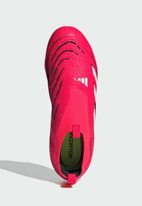 Scarpa da calcio rosa brillante con tomaia testurizzata, caratterizzata da un design aderente, dettagli neri e tre strisce bianche lungo il lato.