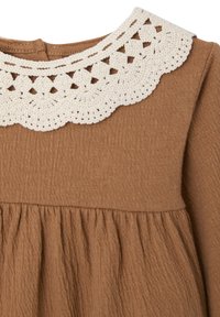 Braunes Kleid mit strukturiertem Stoff, einem gehäkelten weißen Kragen und gerafftem Saumdetail.