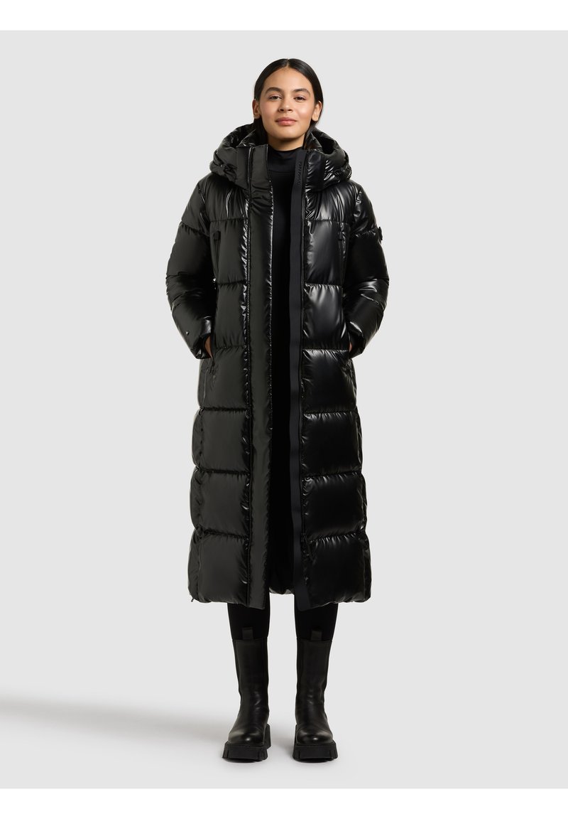 Melnas pūktu dūnu jaka ar spīdīgu apdari, kapuci, garu garumu un lodveida izšūtu dizainu. Aprīkota ar sānu kabatām un priekšējo rāvējslēdzēja aizdari.