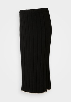 Melnā adīta svārku ar vertikālām ribām, piegulošu jostasvietu un sānu izgriezumu ar dekoratīvu zelta akcentu apakšmalā.