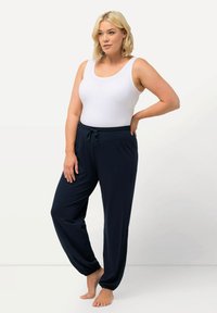 Vit linne och marinblå joggarbyxor med elastisk midja och dragsko, slät textur och avsmalnande mudd.
