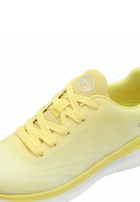 Yellow athletic shoe featuring a mesh upper, flat laces, and soft sole with wavy design accents. Silvery logo at the heel.