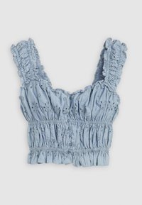 Top court bleu clair avec des bretelles froncées, un corsage smocké et des détails floraux brodés. Tissu doux et texturé avec un ourlet froncé.