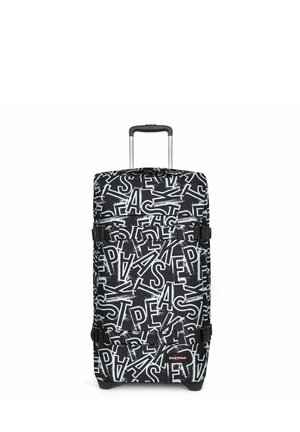Valise rigide noire et blanche avec un motif abstrait de logo Eastpak, poignée télescopique et deux sangles latérales réglables.