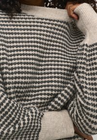 Gestrickter Pullover mit einem grau-weißen gestreiften Muster, der einen weiten Halsausschnitt und gerippte Bündchen hat. Die Textur wirkt weich und gemütlich.