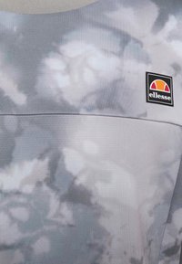 Sudadera gris con un patrón similar a una nube y un cuello texturizado. Presenta un logo de ellesse en un parche rectangular en el pecho.