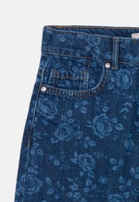 Blå denimjeans med blommönster, featuring hög midja, framficka och synlig sömnad. Metallknapp och etikett detaljerad.