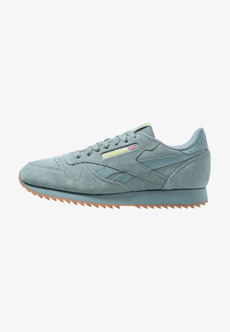 Light blue suede sneaker with rubber sole, tonal accents, and textured design. Features Reebok logo on the side and lace-up closure.