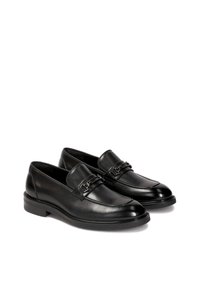 Schwarze Leder-Lederschuhe mit glatter Oberfläche, mit einer dekorativen Metall-Schnalle an der Vorderseite und einem niedrigen, stabilen Absatz.