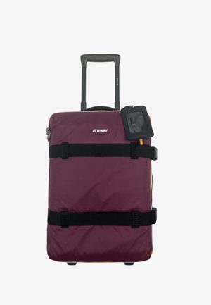 Valigia compatta bordeaux con ruote, cinghie nere, manico esteso e porta identificativo nero attaccato, su sfondo bianco.