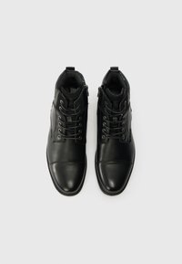 Botine negre din piele cu o textură netedă, având șireturi frontale, fermoare laterale și un design cu vârf rotund.