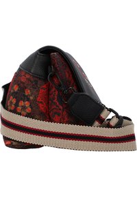 Tekstilpose med et blomstrende rødt og sort mønster, læderdetaljer og en beige rem med røde og sorte striber. Kompakt form, lynlåslukning.