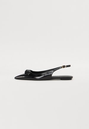 Bailarinas negras de talón abierto con punta afilada, material de cuero brillante y detalle de nudo decorativo en la parte delantera. Correa ajustable con hebilla.