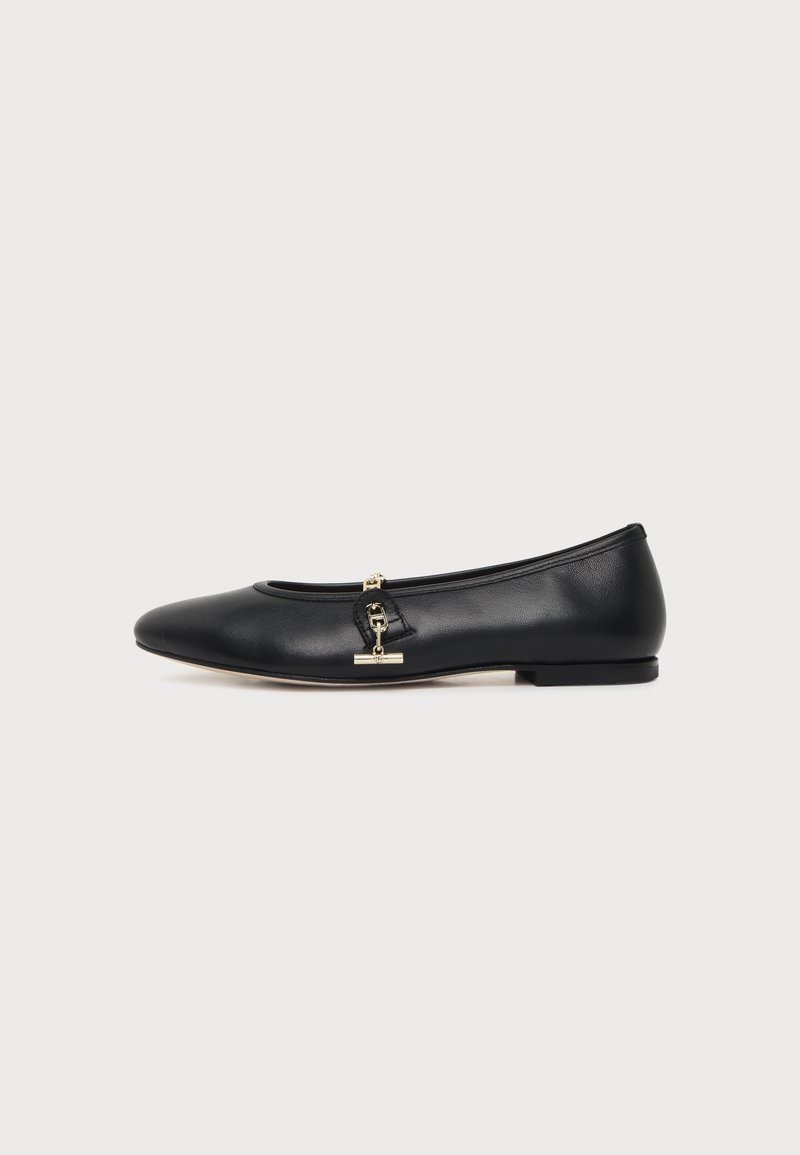 Chaussure plate en cuir noir avec bout arrondi et petit détail de boucle dorée sur le côté, présentée sur un fond clair uni.