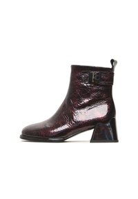 Ankle boots made of glossy burgundy material with a textured finish, featuring a chunky black heel and a decorative buckle on the side.