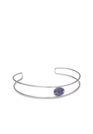 Pulsera de brazalete abierto de plata con dos bandas finas y una sola piedra azul ovalada colocada en un lado.
