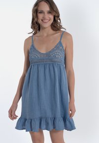 Abito di denim con corpetto in crochet aderente, spalline regolabili e orlo svasato con volants. Tessuto azzurro chiaro, texture morbida.