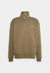 Sweat-shirt vert olive avec un col montant, une fermeture éclair demi-longue et des poignets côtelés. Présente le logo "LES DEUX" brodé en blanc sur le devant.