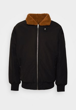 Μαύρο μπουφάν με καφέ, χνουδωτό γιακά. Διαθέτει μπροστινό φερμουάρ, πλεκτούς μανικιών και πλαϊνές τσέπες. Κατασκευασμένο από ομαλό, ανθεκτικό υλικό.