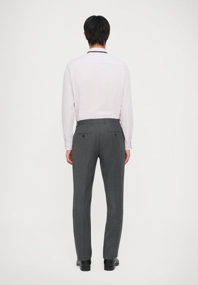 Camisa de manga larga de color rosa claro con corte entallado, pantalones grises con textura sutil y dos bolsillos traseros, acompañados de zapatos negros.