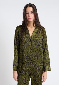 Groene pyjama-top met bloemenpatroon, lange mouwen, kraag en knopen. Gemaakt van gladde stof met een relaxed fit.