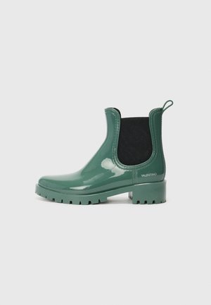 Green rubber Chelsea boots with a glossy finish, black elastic side panels, a textured sole, and a back pull tab. Marked with "Valentino."