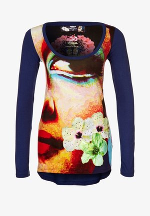 Top de manga larga azul marino con un estampado colorido de un rostro abstracto y tres apliques florales bordados en la parte delantera.