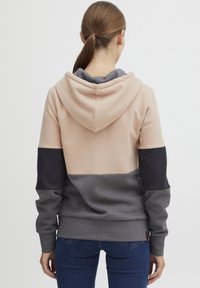 Hoodie u ružičastim, sivim i tamnosivim panelima; mekan materijal; rebrasti rubovi i donji rub; vidljivi detalji šivanja; opušteni kroj.