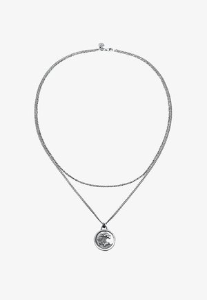 Collier en argent à double chaîne avec un pendentif rond au design de vague, mettant en valeur une surface texturée et un fermoir.