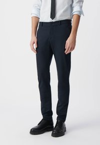 Marineblauwe op maat gemaakte broek met een slim fit, gemaakt van gladde stof, voorzien van riemlussen, een knoopsluiting en zijzakken.